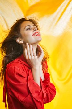 smiling woman in red dress posing yellow background. High quality photo