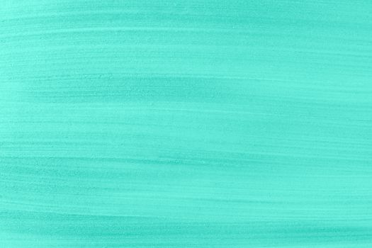 Light glossy turquoise acrylic paint textured background close up. Top view, copy space.