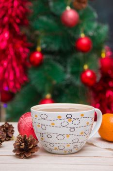 cup of coffee on the background of a festive Christmas tree