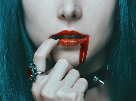 Beautiful sexy vampire woman with red lips in blood, close-up.