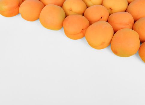 Apricot on a white background, arranged on top right corner, with copy space. Top view, close up.