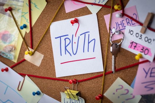 Truth search concept. Close-up view of a detective board with evidence. In the center is a white sheet attached with a red pin with the text Truth.