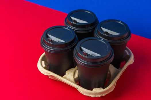 Black take away coffee cups in holder on table