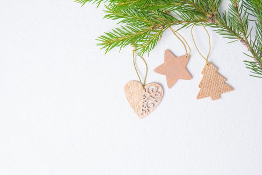 wooden Christmas toys in the shape of a heart and stars on a fucking background, fir branches and eco friendly Christmas toys, top view copy place