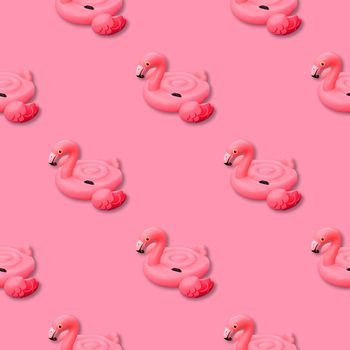 Pink flamingo monochrome background. Swimming pool toy in shape of pink flamingo seamless pattern. Flamingo inflatable cut out. Top view, flat lay.