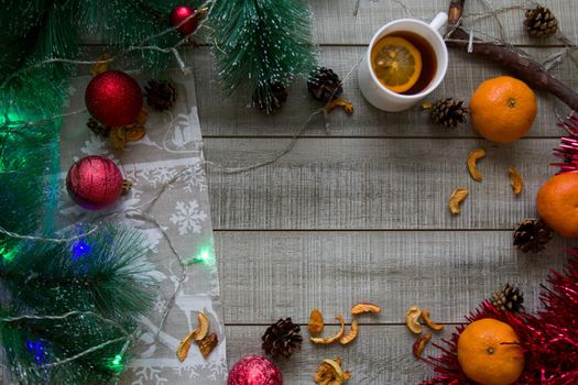 Christmas Christmas background, winter mood, copy space top view gray wooden background, pine branches, garland, cup of lemon tea, cones, branch, dried fruits