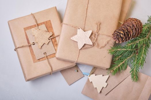 several boxes of gifts packed in eco paper on the table, zero waste lifestyle concept, packaging for DIY gifts, top view, gray background, eco christmas