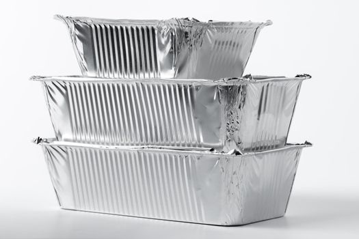 Takeaway meal in foil food box on white background close up