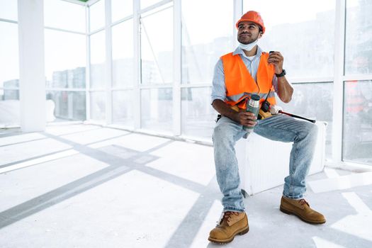 Portrait of a man worker in workwear on a break drink coffee and have rest, close up