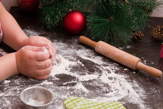 little girl makes christmas cookies, christmas background, bright colors, red christmas tree decorations, copy space