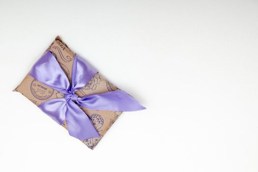 present on a white background with lilac ribbon bow brown paper