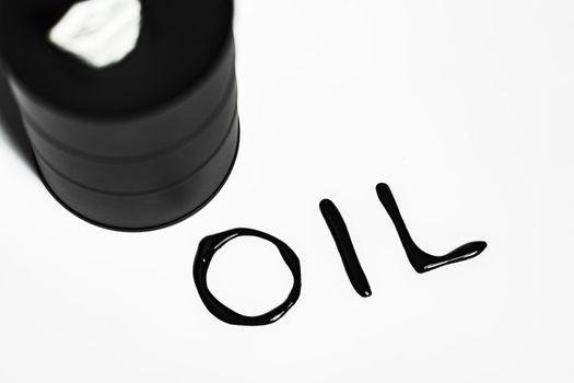 Oil industry concept. Spilled oil from a mini barrel isolated on a white background