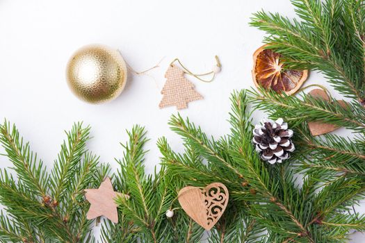 christmas tree toys and natural spruce branches on a white background top view copy place, homemade eco friendly Christmas tree toys on fresh spruce branches