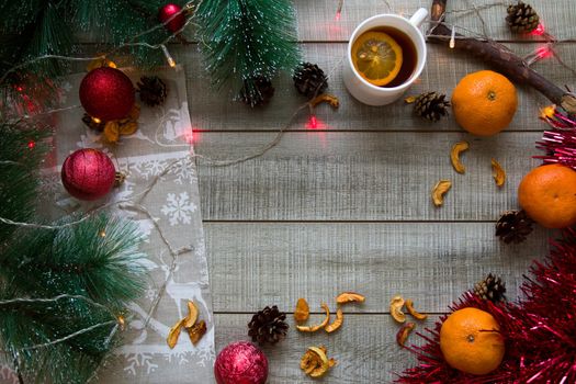christmas christmas background, top view copy space gray wooden background, pine branches, garland, cup of lemon tea
