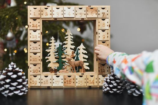 Girl opens wooden advent calendar