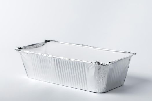 Foil food box with takeaway meal on white background close up