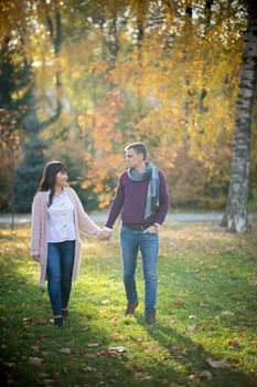 Autumn. Loving couple walk holding hands in the park