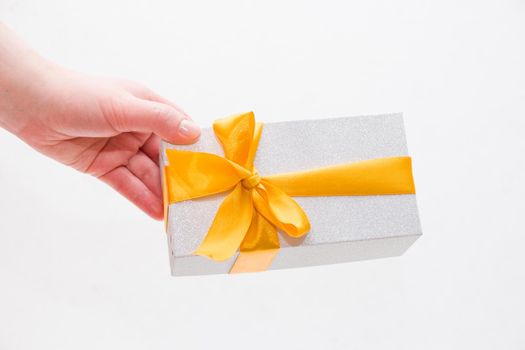 pink shiny gift box on a light white background with pink polka dot bow top view