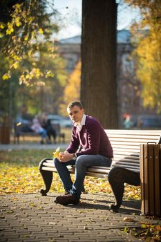 Autumn. A man sitting on a bench in the autumn park