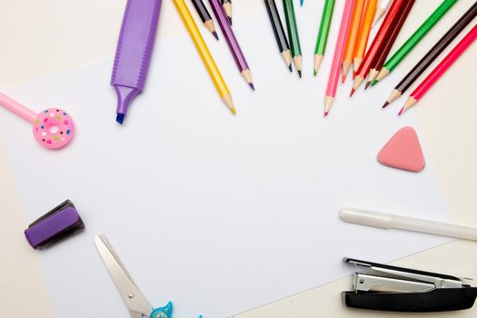 stationery pencils colored highlighter scissors blue childish stapler eraser pen white pink donut on a cap white sheet of paper place copy top view back to school