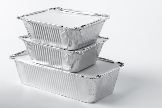 Foil food box with takeaway meal on white background close up