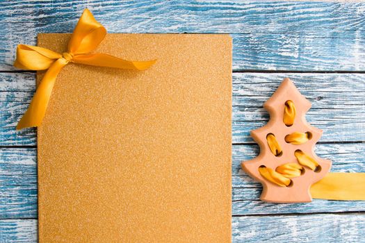 shiny golden background and toy tree made of wooden on a blue background place copy top view christmas background new year card