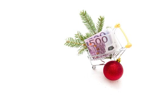 concept of purchases before Christmas, New Year's decor and a 500-euro note in a shopping trolley on a white background copy space isolation