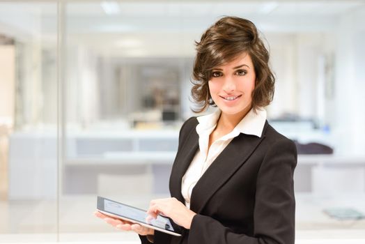 Portrait of young pretty business woman with tablet computer in the office