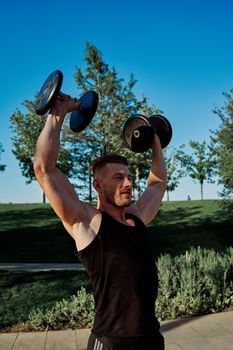 sporty man exercise fitness workout outdoors with dumbbells. High quality photo