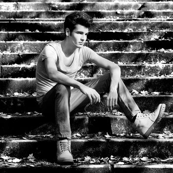 Portrait os an attractive young handsome man, model of fashion in stairs