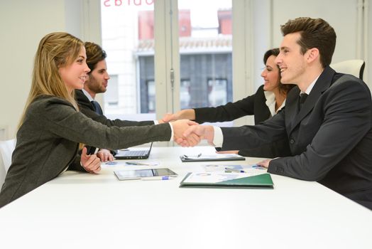 Four business people shaking hands, finishing up a meeting