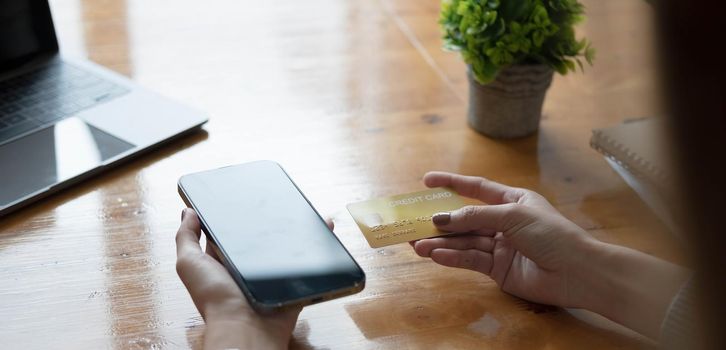 Online payment,Young woman's hands using computer and hand holding credit card for online shopping.