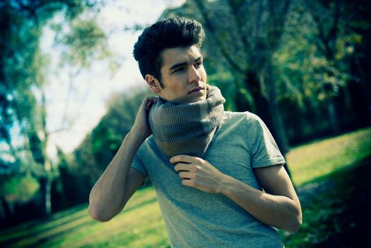 Portrait of a young handsome man, model of fashion, with toupee in the park