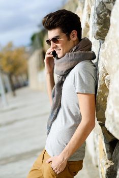 Portrait of handsome man in urban background talking on phone