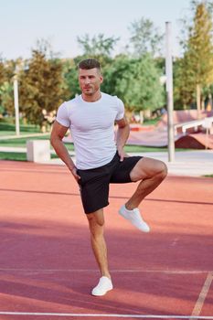 athletic men doing exercises on the sports ground in summer. High quality photo