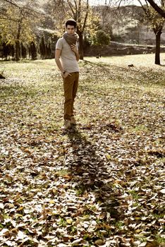 Portrait of a young handsome man, model of fashion, with modern hairstyle in the park