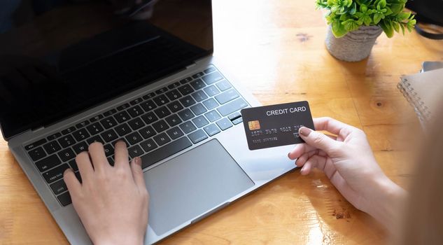 woman shopping online with credit card. woman holding credit card and using laptop. Online shopping concept.