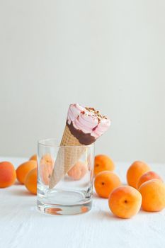 icecream cone at the glass with apricots. ice cream with apricot