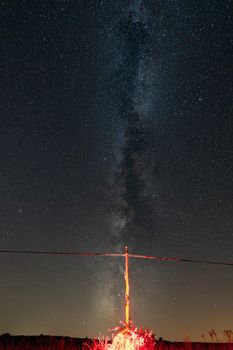 Antique wooden power line with red base under the milky way