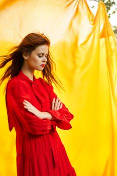 pretty woman in red dress nature yellow cloth on background. High quality photo