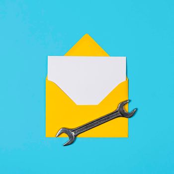 Happy father's day banner with copy space. Man or husband concept. Yellow Envelope and wrench on blue background. Happy labor day