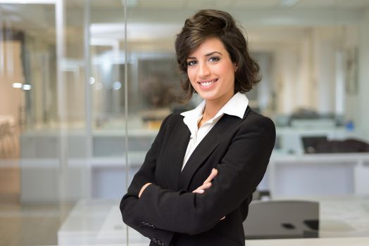 Portrait of a business woman in an office. Crossed arms