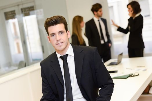 Image of business leader looking at camera in working environment