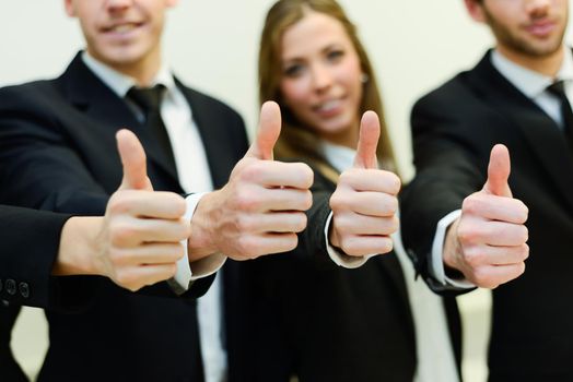 Close-up of business team holding their thumbs up