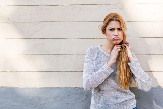 Funny girl with the face of protest. Woman snorting in urban background