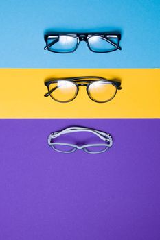 several different glasses on a colorful background, top view, buying glasses, a store of glasses and frames for glasses, children's glasses and glasses for adults