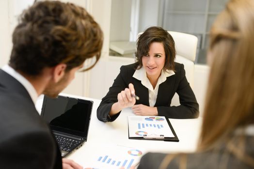 Image of business partners discussing documents and ideas at meeting. Woman leader wearing blazer