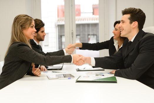 Four business people shaking hands, finishing up a meeting