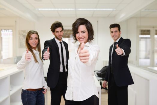 Portrait of cheerful business group giving thumbs up