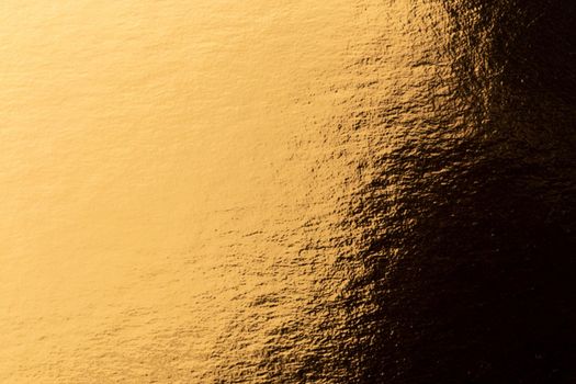 Abstract texture of golden metal macro shot background at close range.